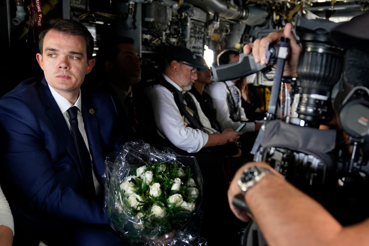 Un miembro del personal de la Casa Blanca sostiene las flores que los Biden colocaron frente a la Escuela Primaria Robb.