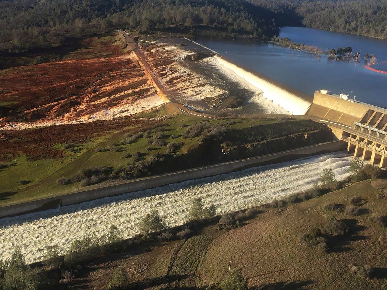 Una foto aérea publicada por el Departamento de Recursos Hídricos de California muestra el vertedero dañado con ladera erosionada en Oroville, California.