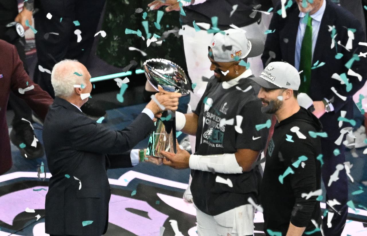El propietario, presidente y director ejecutivo de los Philadelphia Eagles, Jeffrey Lurie, entrega el trofeo Lombardi al mariscal de campo número 01 Jalen Hurts y al entrenador en jefe Nick Sirianni al final del Super Bowl LIX.