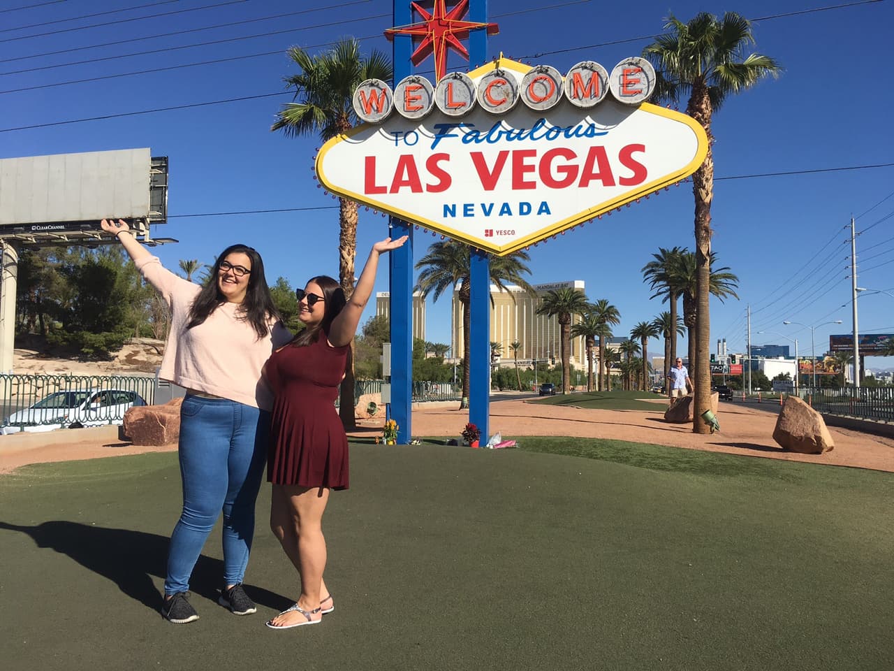 Dos turistas españolas posan sonrientes frente al cartel que da la bienvenida a Las Vegas en el corredor de casinos.