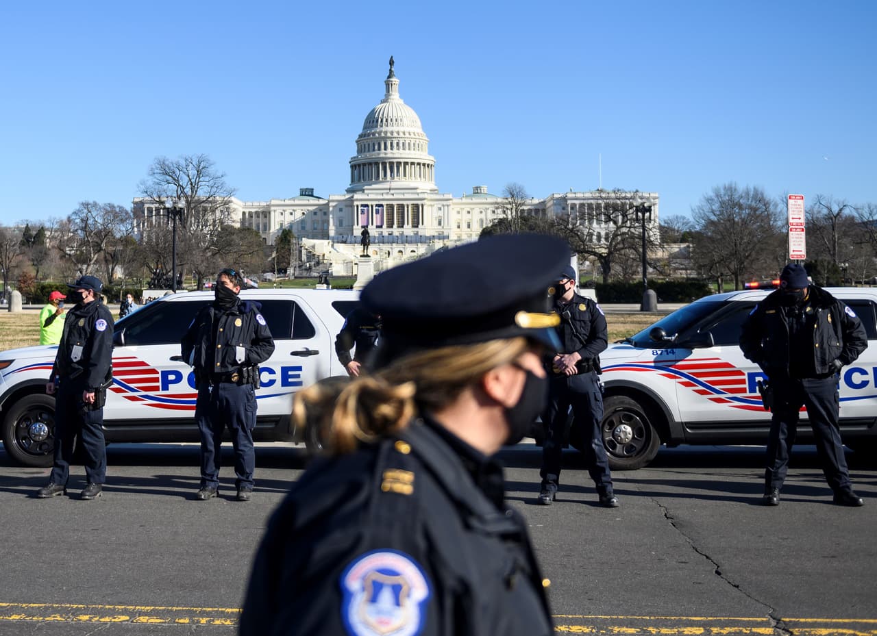 Agentes de la policía de Washington estacionan sus patrullas y se colocal de pie antes de que el ataúd con el oficial de policía caído, Brian Sicknick, pase durante un cortejo fúnebre en la capital del país, frente al Capitolio.