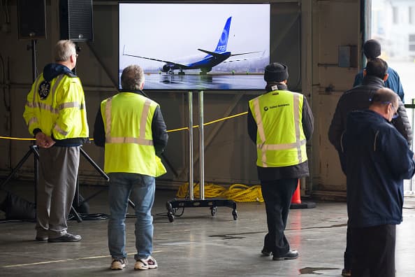 Los empleados observan en un galpón ubicado en el aeropuerto en la planta de la compañía en Everett, estado de Washington.
