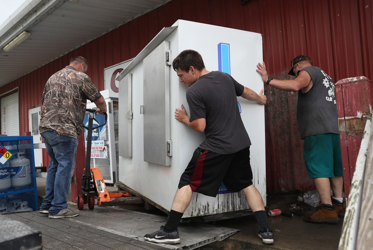 Empleados retiran una máquina de hielo del exterior de una tienda en Cameron. Las autoridades de Houston pidieron a los residentes que preparen suministros en caso de que se queden sin electricidad durante unos días o necesiten evacuar sus viviendas.