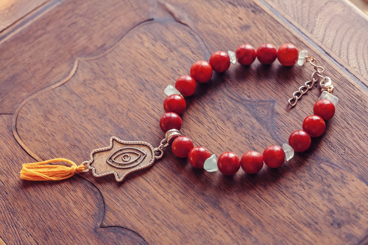 En otros países se preparan amuletos con coral rojo y negro que se engarzan a una especie de cadenita o pedacito de tela y se le pone al bebé en la muñeca o colgado en sus ropitas con un imperdible.