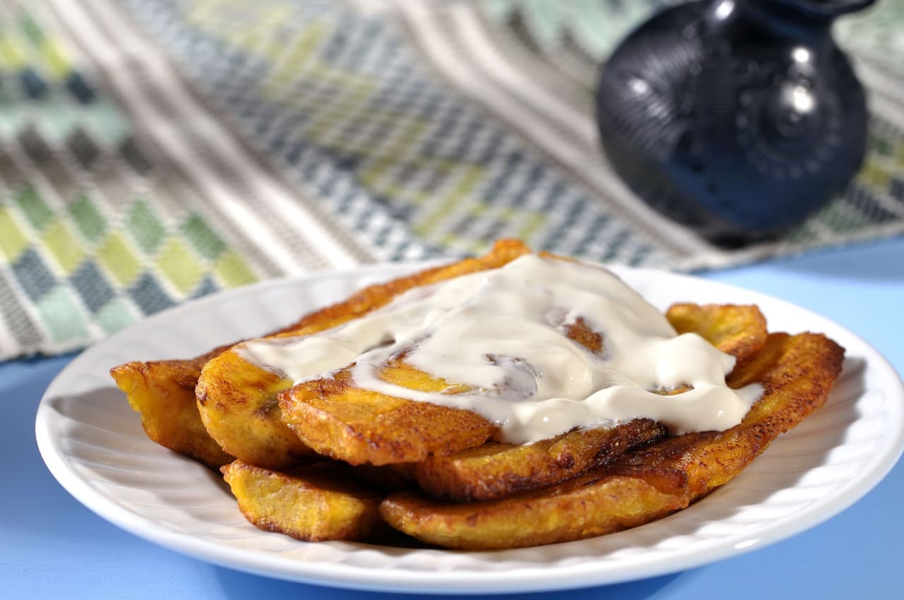 Pila de plátanos fritos y crema. Es un plato que contiene pocos elementos, aunque es muy rico al paladar. Se puede combinar con distintos tipos de cremas y de quesos rallados. Es muy practico para fiestas y reuniones.