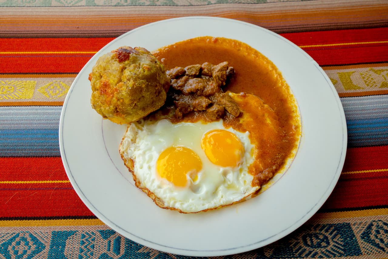 Bolón de verde con huevos fritos y estofados de carne, es una comida ecuatoriana. Este platillo habitualmente se consume para desayunar o merendar a lo largo del día. Se acostumbra a servir con café y con huevos fritos.