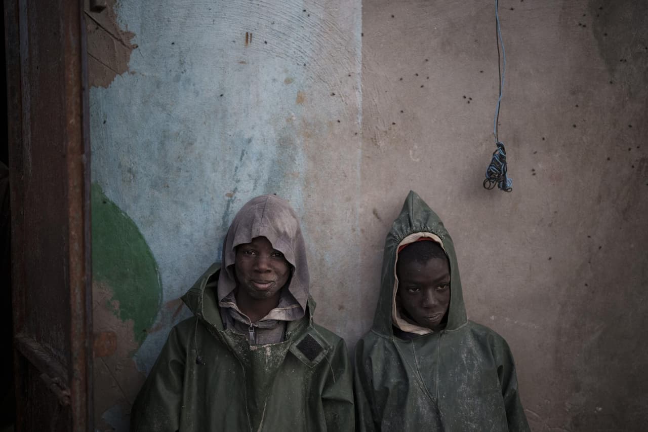 Dos jóvenes pescadores de Senegal se apoyan contra una pared tras una expedición de pesca en Nuadibú, Mauritania, el 1 de diciembre de 2021.