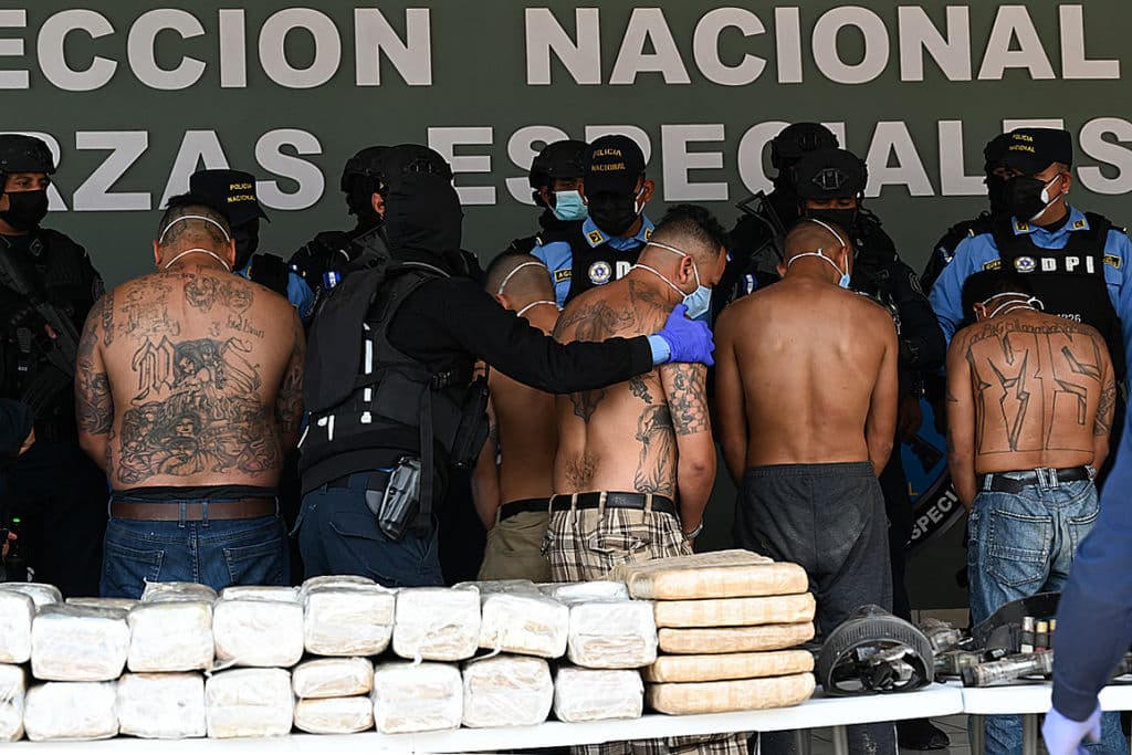 Members of the criminal gang Mara Salvatrucha (MS-13) are escorted by officers of the National Police in Tegucigalpa on February 19, 2021, after the dismantling of an operations centre of the organisation found in the mountains of the department of Olancho, north of Honduras.