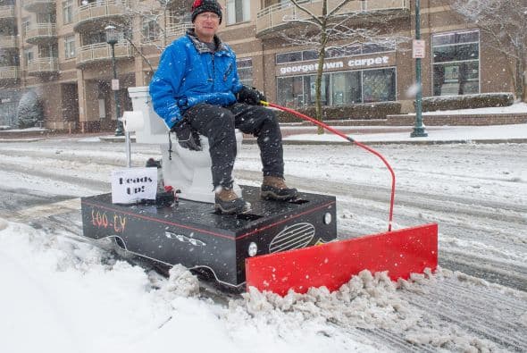 David Goldberg de 55 años y propietario de una ferretería, conduce su quitanieves híbrido eléctrico con un inodoro abajo, en Bethesda, Maryland.