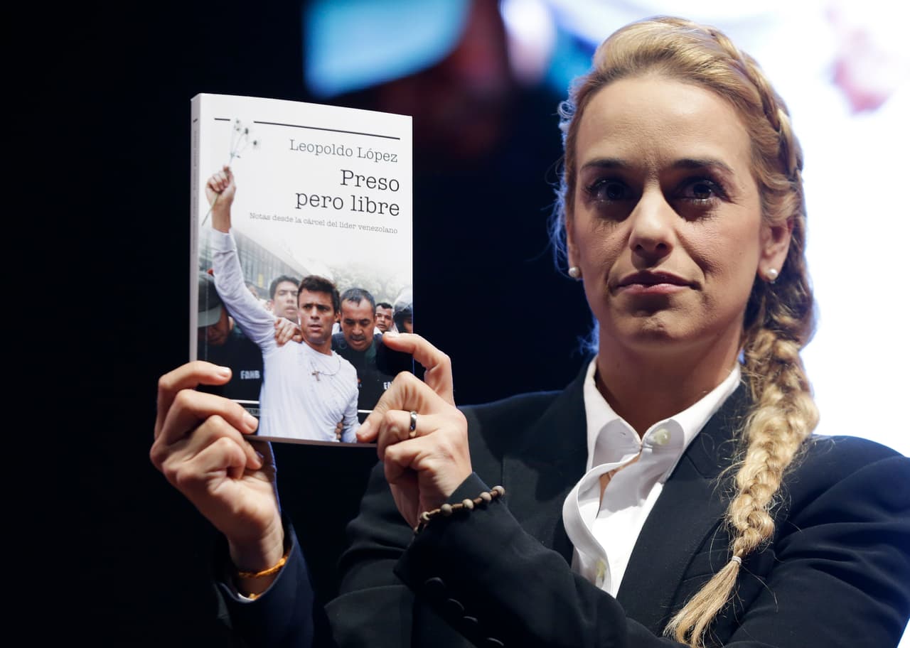 Lilian Tintori, Leopoldo López's wife, holds up a copy the imprisoned opposition leader's book in Bogota, Colombia in May.