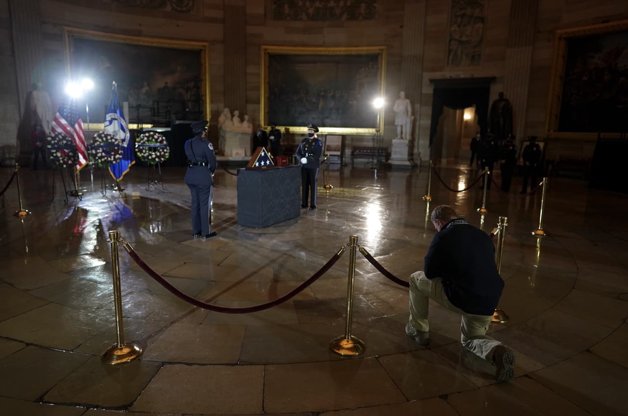Un oficial, de rodillas, rinde sus respetos a los restos del oficial Brian Sicknick, quien murió a consecuencia de los golpes que recibió por una turba de simpatizantes de Donald Trump que buscaban interrumpir la certificación de las elecciones del 3 de noviembre de 2020, convencidos de un supuesto "fraude" del que el empresario no pudo demostrar prueba alguna.