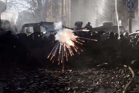 La policía ucraniana cercó hoy a los manifestantes en el corazón de las protestas opositoras de la plaza de la Independencia de Kiev (Maidán), tras una jornada en la que murieron 14 personas en los disturbios que estallaron en la capital. Víktor "Yanukóvich se ha convertido en un presidente sangriento", aseguró hoy el dirigente opositor Vitali Klitschkó en un llamamiento a los países democráticos para que intervengan en Ucrania y frenen la violenta confrontación. Según se acercaba la medianoche, los temidos Berkut, el destacamento antidisturbios, estrechaban el cerco en torno a los miles de manifestantes concentrados en el Euromaidán, bastión de las protestas desde el pasado 21 de noviembre. "Los extremistas de la oposición han cruzado la línea roja; matan a inocentes en la calles de la capital de Ucrania, vejan a mujeres, queman edificios y automóviles. Y si los disturbios continúan, nos veremos obligados a actuar con firmeza", rezaba el ultimátum del Servicio de Seguridad y el Ministerio del Interior de Ucrania. Advierten a los americanos que se queden dentro de las casas y de nuevo se sienten explosiones en la ciudad.