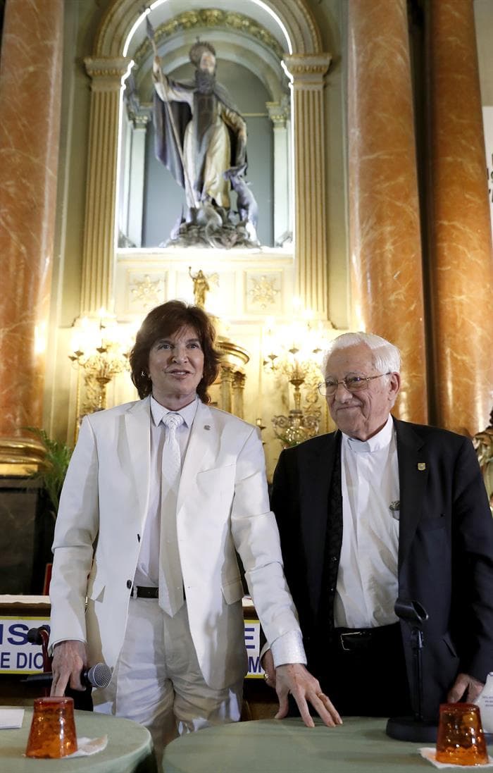 Camilo Sesto, quien se recupera de una lesión en la cadera, se puso de pie para dirigirse al público. A su lado, el padre Ángel García.