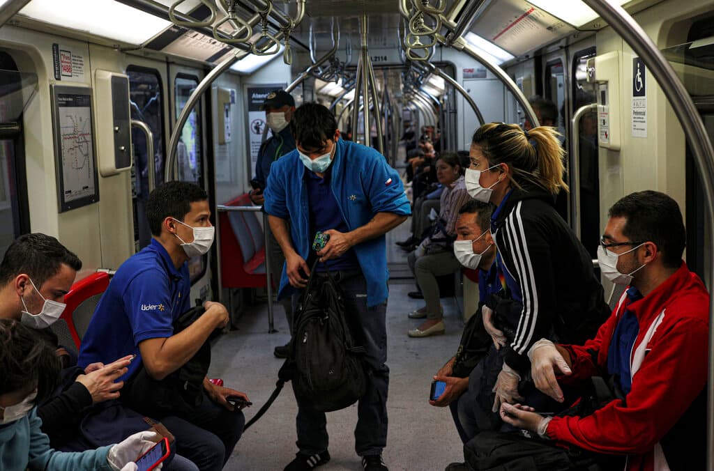 Los trabajadores de supermercados usan mascarillas como precaución contra la propagación del nuevo coronavirus en el metro de Santiago de Chile, el miércoles 18 de marzo de 2020.
