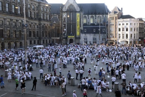 Personas vestidas de blanco se reúnen en la Plaza Dam en Amsterdam durante una marcha del silencio en memoria de las víctimas.