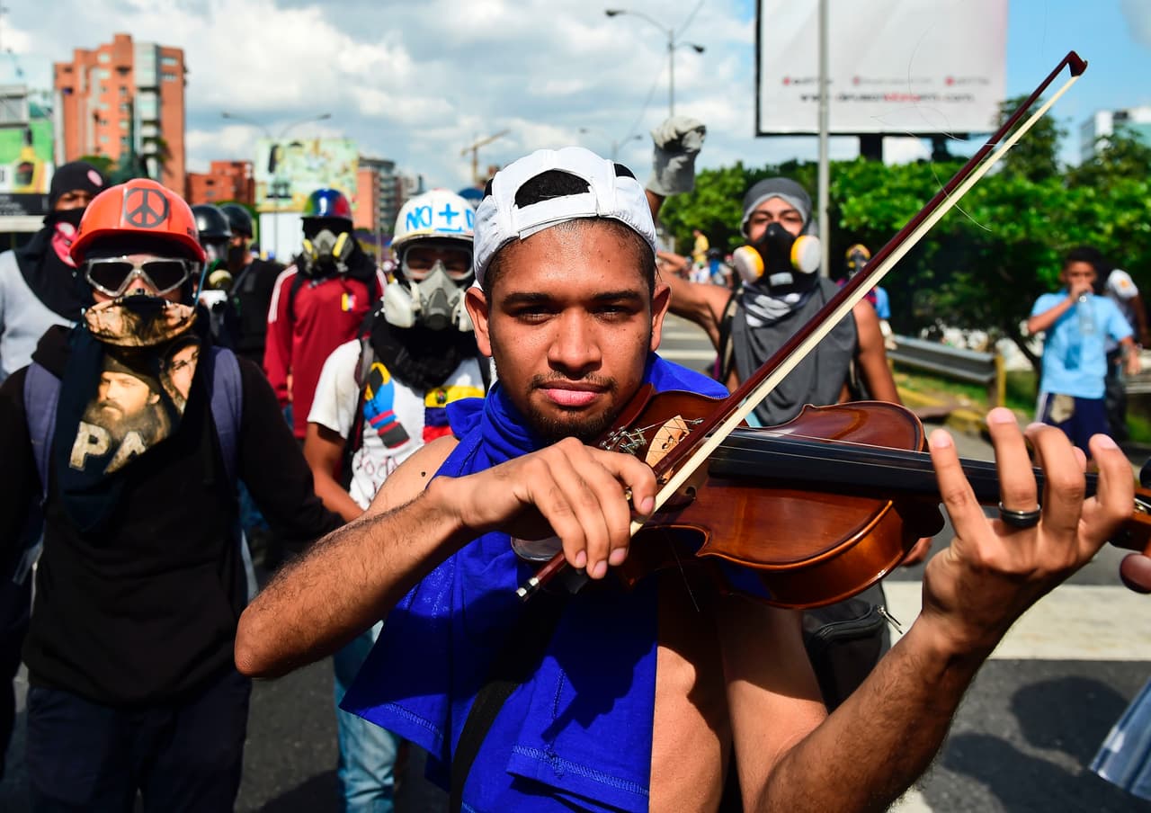 A violinist plays his instrument during a protest Saturday on a highway in Caracas. May 6, 2017.