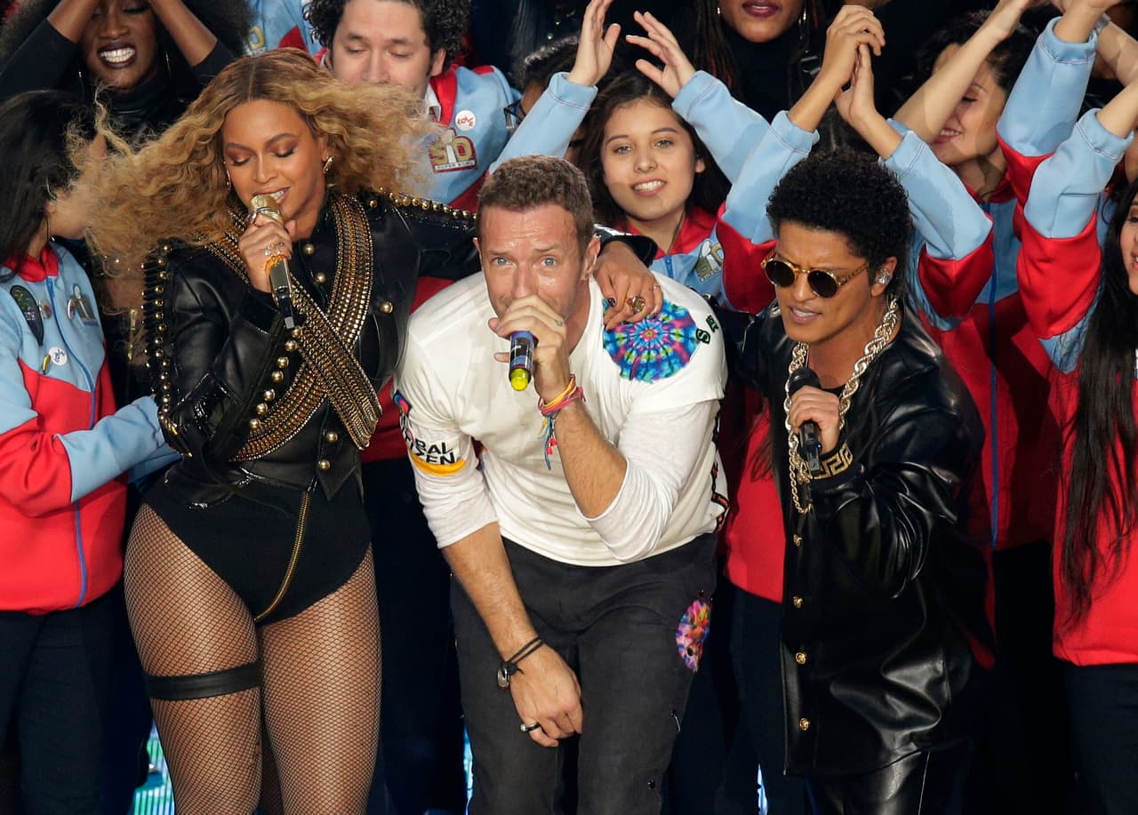 Chris Martin de Coldplay, centro, durante su presentación con Beyonce,izquierda y Bruno Mars en el espectáculo de medio tiempo del Super Bowl 50 de la NFL el domingo 7 de febrero de 2016 en Santa Clara, California. (Foto AP/Charlie Riedel)