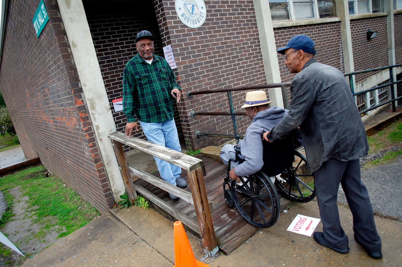 Un grupo de votantes de Montgomery, Alabama, salen y entran de un centro electoral. En este estado los demócratas se disputan 52 delegados.