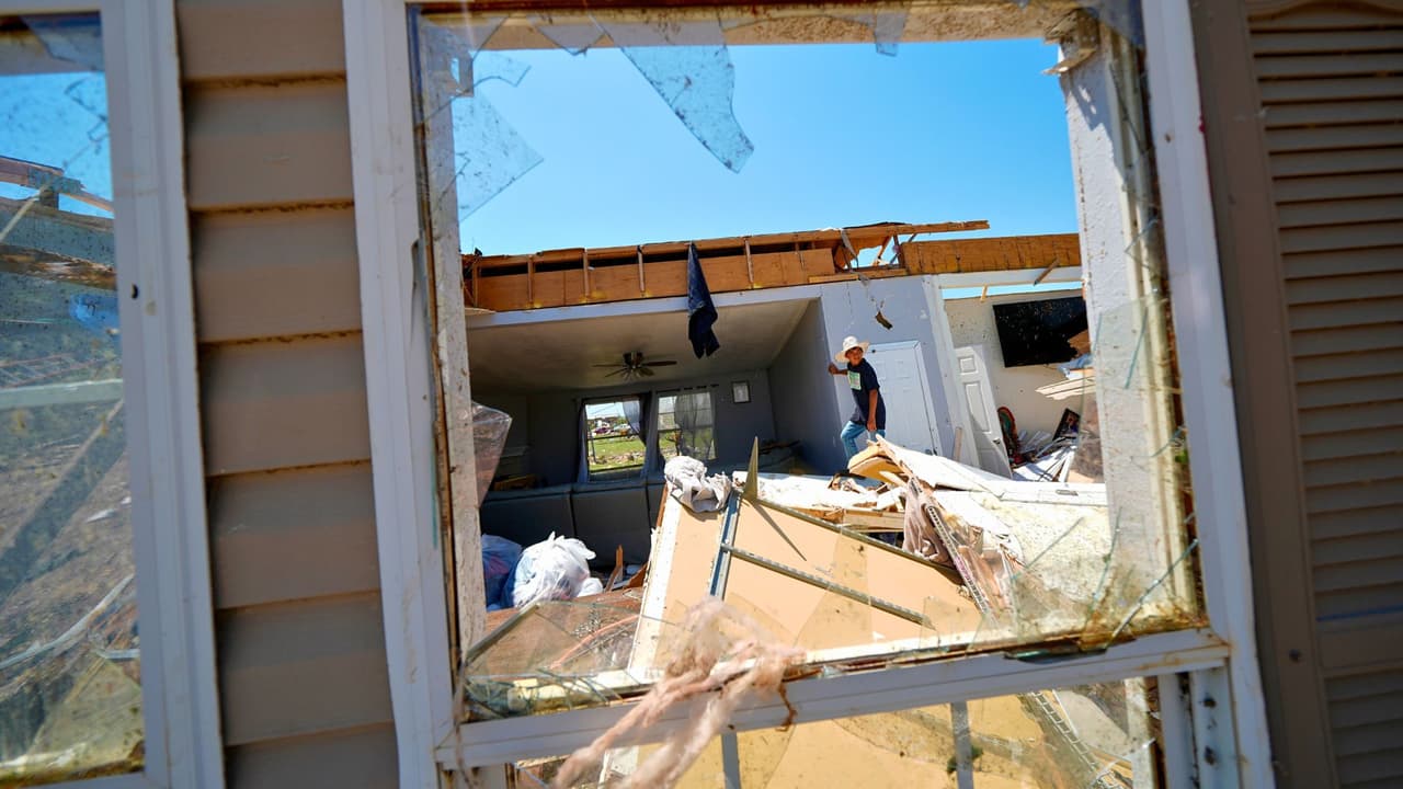 Larry Landeros, de 9 años, que sobrevivió a un tornado mortal con sus padres la noche anterior, inspecciona su casa destruida, el domingo 26 de mayo de 2024, en Valley View, Texas.