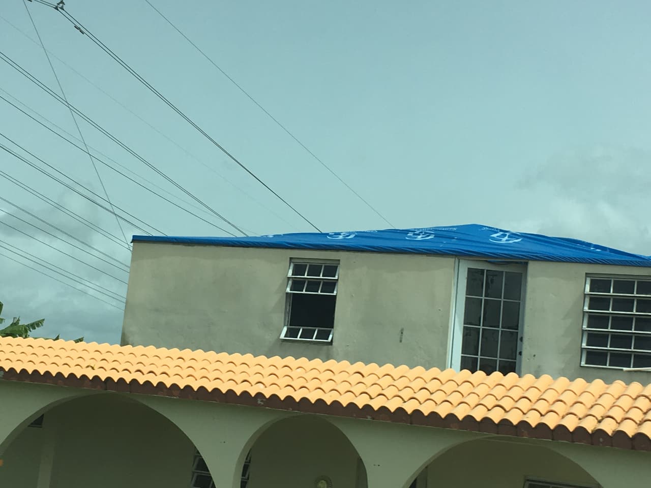 Los toldos azules que cubren algunos techos fueron proporcionados por FEMA. Algunas casas continúan usándolos.