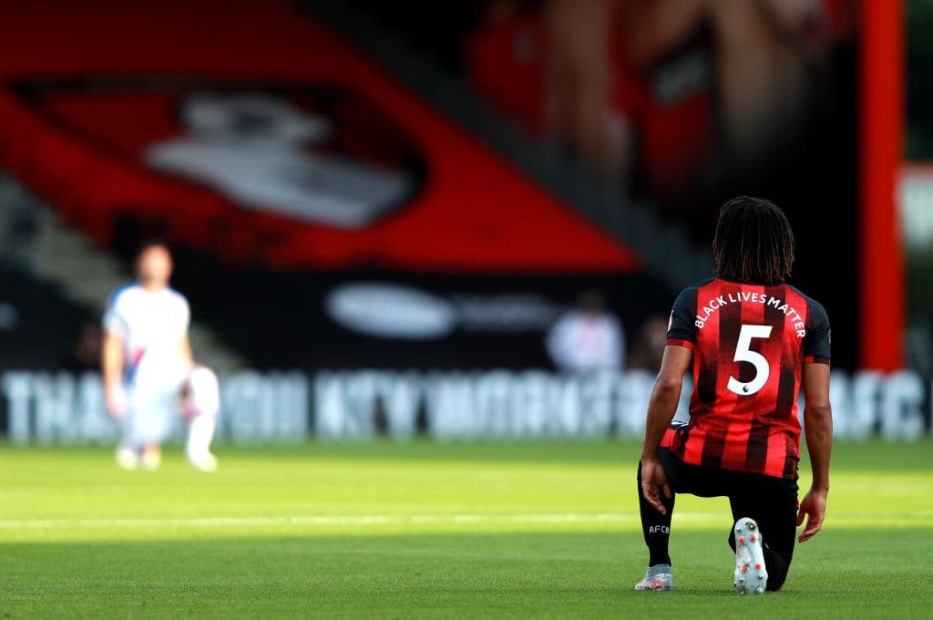 Nathan Ake del Bournemouth con la rodilla en el césped y el respeto solidario con el movimiento.