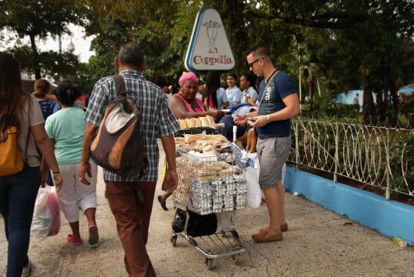 Un vendedor ambulante vende panes de dulce afuera de la heladería Coppelia.