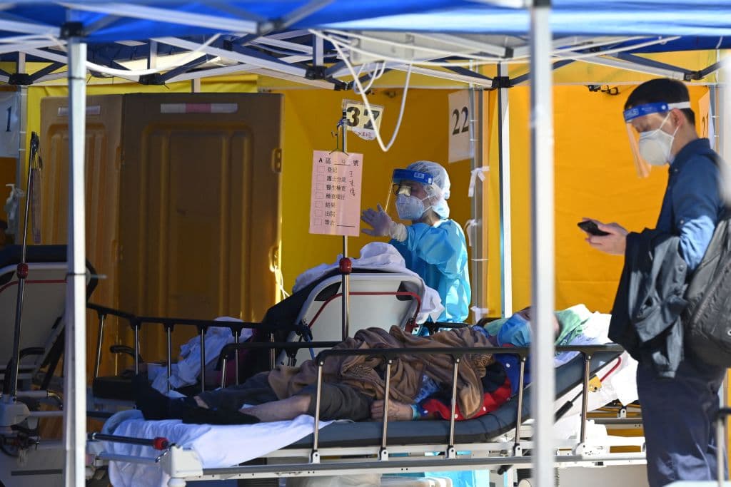 Un paciente es atendido fuera del hospital Caritas en Hong Kong. El diario 
<i>The Washington Pos</i>t cita a doctores en la ciudad que cuentan que el nivel de colapso en los hospitales es tan grande, que en algunos 
<b>tienen dificultad para acceder a los pacientes entre tantas camillas apiñadas.</b> Lo mismo está ocurriendo en las casas de cuidado de ancianos que, en algunos casos, no estaban equipadas para aislar a los pacientes y por ende, batallan para frenar la contagiosa variante ómicron.