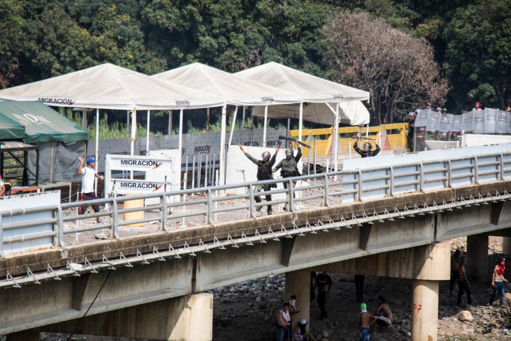 Tres guardias nacionales cruzan el puente Simón Bolívar el sábado, tras haber desertado.