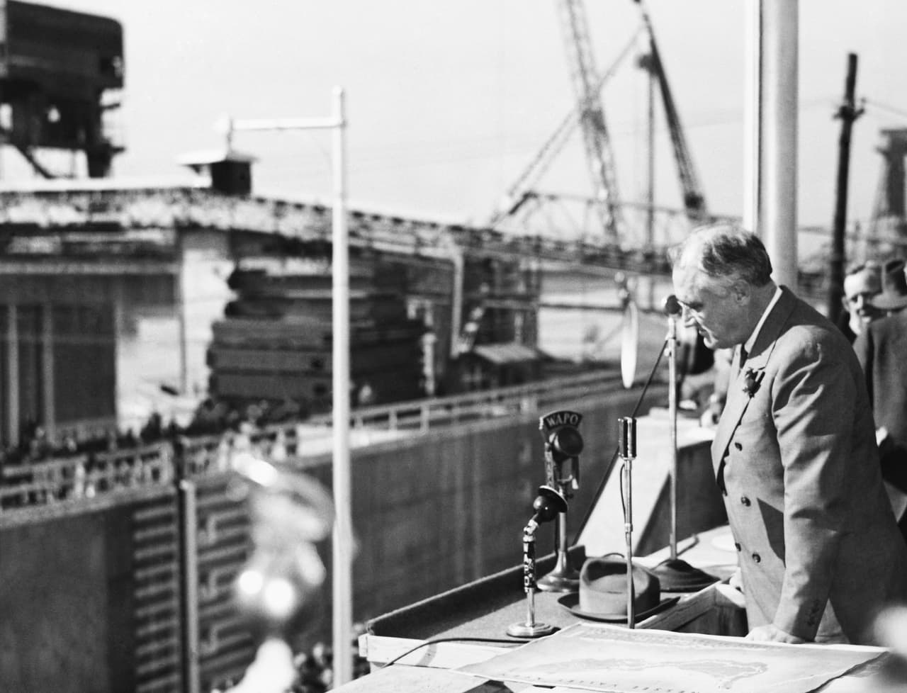 <b>Represa de Chickamauga</b>. 
<br>
<br>Una ley promovida por el ‘New Deal’ en 1933 aprobó la creación de la Autoridad del Valle de Tennessee, una corporación pública para aprovechar los recursos de ese estado. Uno de los proyectos más grandes que asumió esta entidad fue la represa Chickamauga, ubicada en el río Tennessee a las afueras de la ciudad de Chattanooga.
<br>
<br>En la fotografía Roosevelt en una visita a la presa en construcción en 1938. Antes de ser inaugurada en 1940, la región sufría costosos daños por inundaciones y enfermedades transmitidas por mosquitos. 
<br>