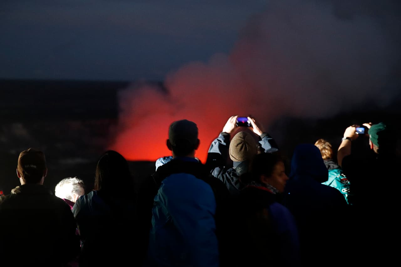 Un grupo de espectadores se mantuvo apreciando la erupción en el caldera del volcán en horas de la noche. En este punto la ceniza y el esmog volcánico se elevó a 12,000 pies (3,657 metros) y flotó hacia el sudoeste, donde bañó autos en una carretera y provocó un aviso de "aire insalubre" en la comunidad de Pahala, a 18 millas del cráter principal.