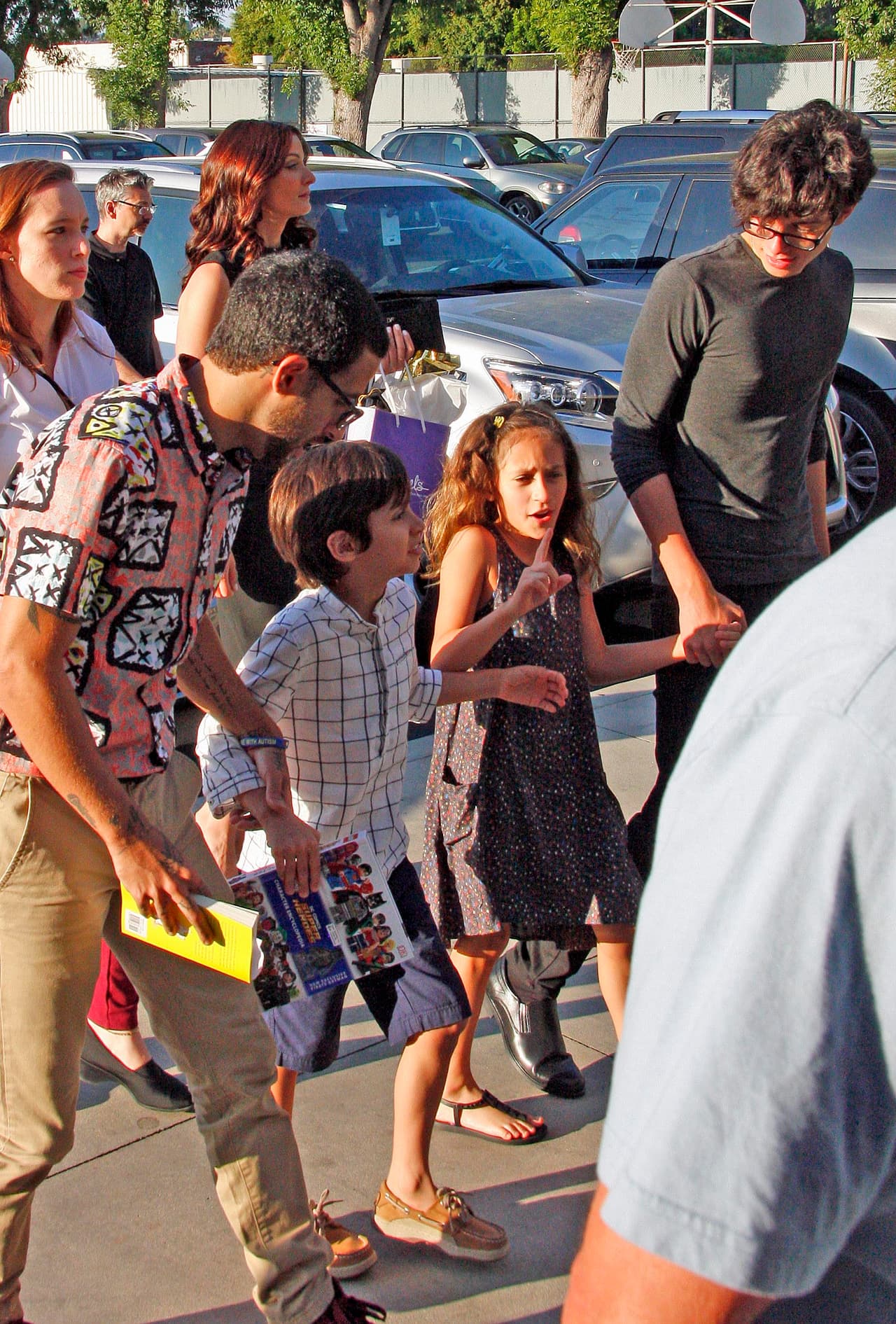 Los gemelos Max y Emme, hijos de Jennifer López y Marc Anthony, iban junto a su hermano mayor Cristian (con camisa gris) y cuya madre, Dayanara Torres, se observa detrás, vestida de negro, cargando una bolsa de regalo violeta.