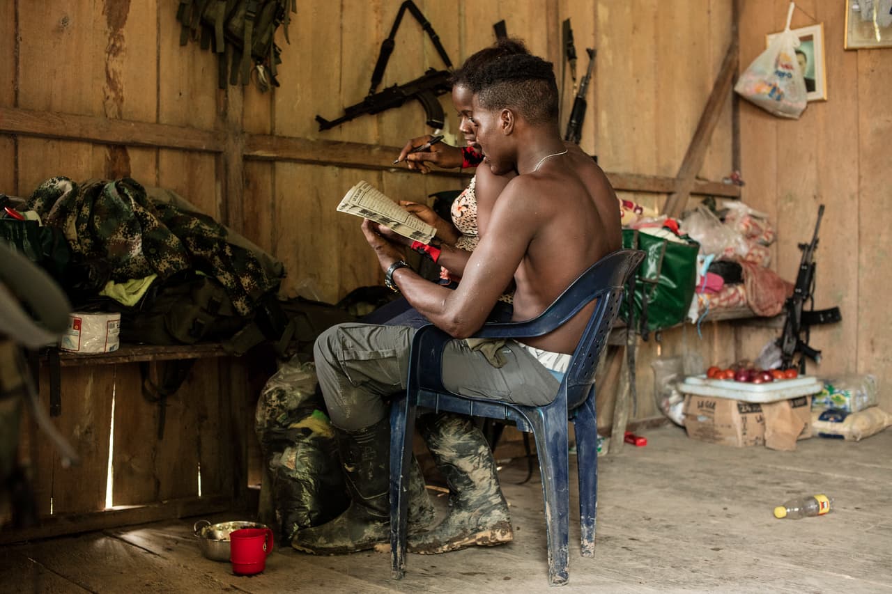 Dos combatientes compartiendo un momento de descanso, en un campamento del FGO en el Pacífico colombiano.