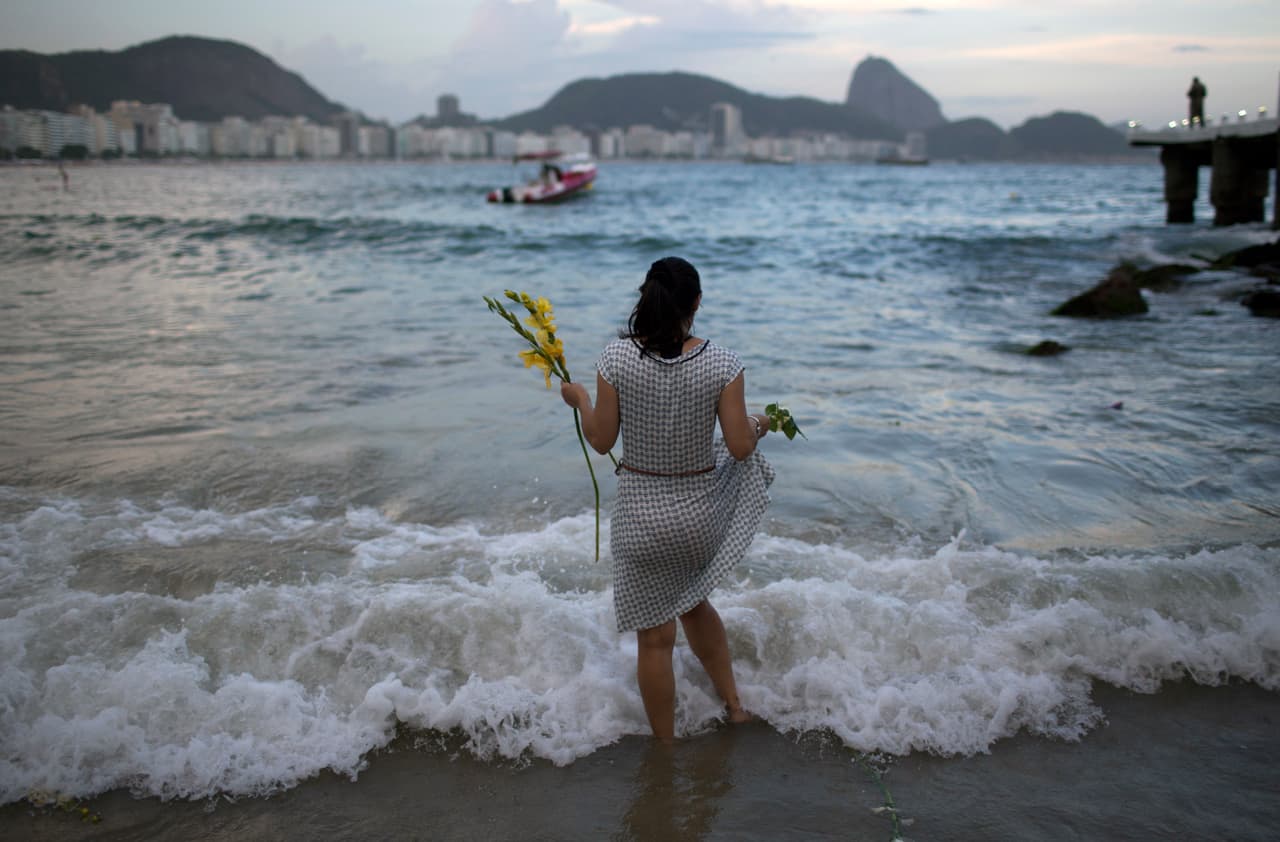 Una mujer ofrece durante el día 31 de diciembre en
<b>Rio de Janeiro</b>, Brasil, flores a Yemanja, diosa del mar, para pedir buena suerte en el año entrante. La creencia en esta diosa procede de los esclavos de África Occidental que llegaron al continente americano.