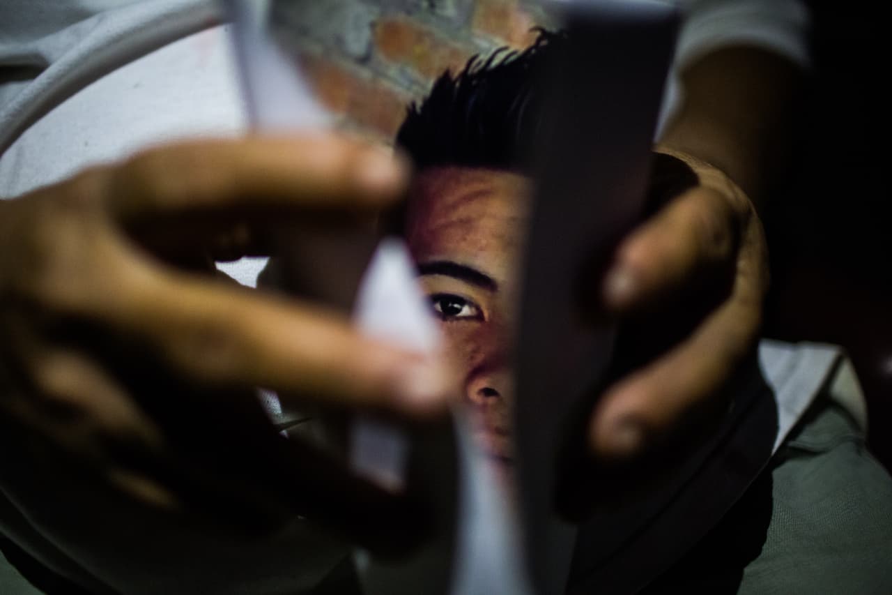 La abuela muestra una foto de su nieto desparecido. Describe al nieto como un muchacho fuerte, al que le gustaba el deporte, sonriente, servicial. "¡Bien parecido, el jodido! ¡Bien parecido!".