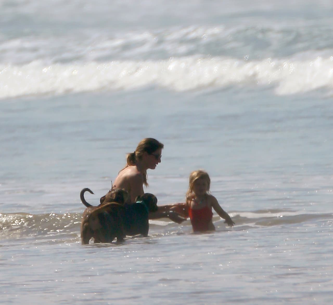 La pequeña Vivian jugando en las olas del mar.