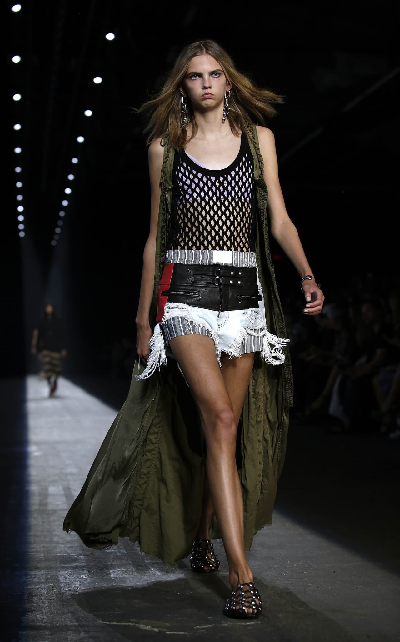 Serán muchas las que este viernes, sábado y domingo se van a vestir así. Unos shorts de dénim blanco deshilado, una camiseta de maya que trasparenta la ropa interior, y un chaleco que crea una capa larga como lo hizo con genialidad Alexander Wang que cada vez es más urbano. Solo falta buscar unas pestañas dramáticas y estarás lista.