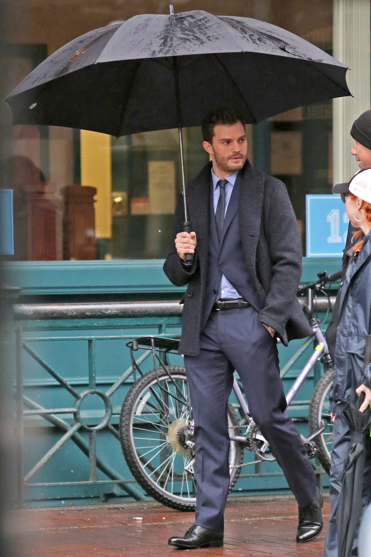 Platica con la producción mientras sigue cargando su paraguas.