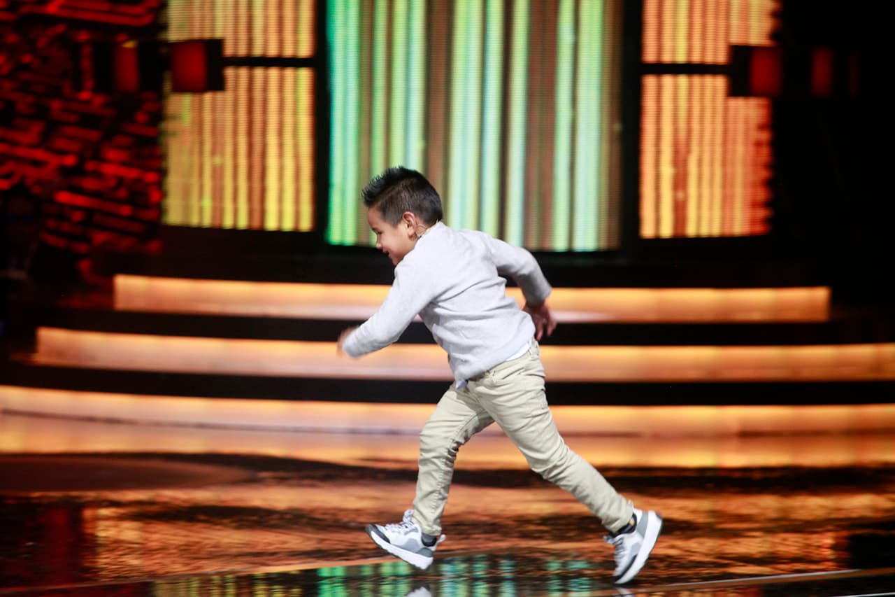 El pequeño entró corriendo al escenario.