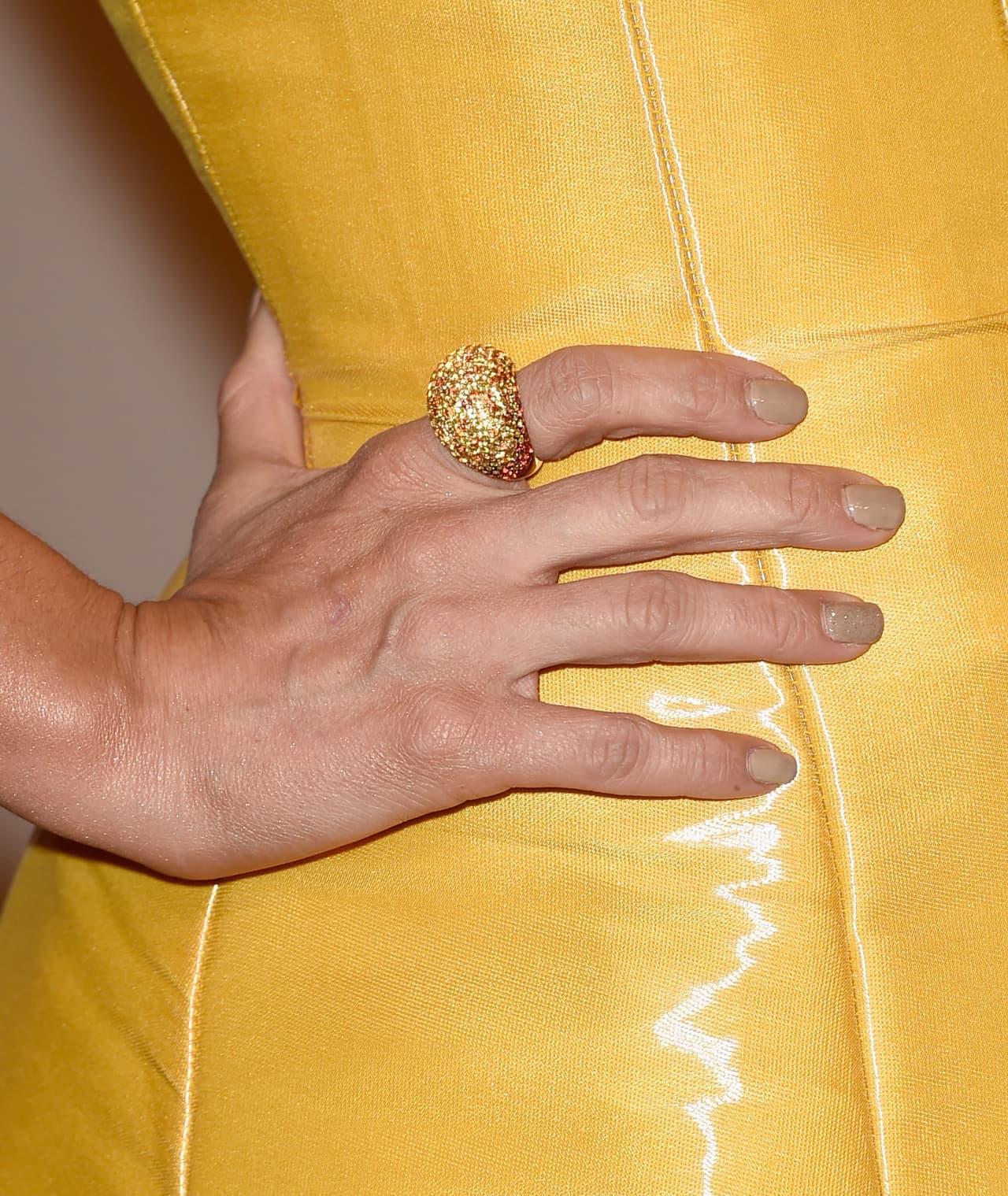 El peso de los accesorios en su mano lo depositó en su anillo, que fue grande y dorado.