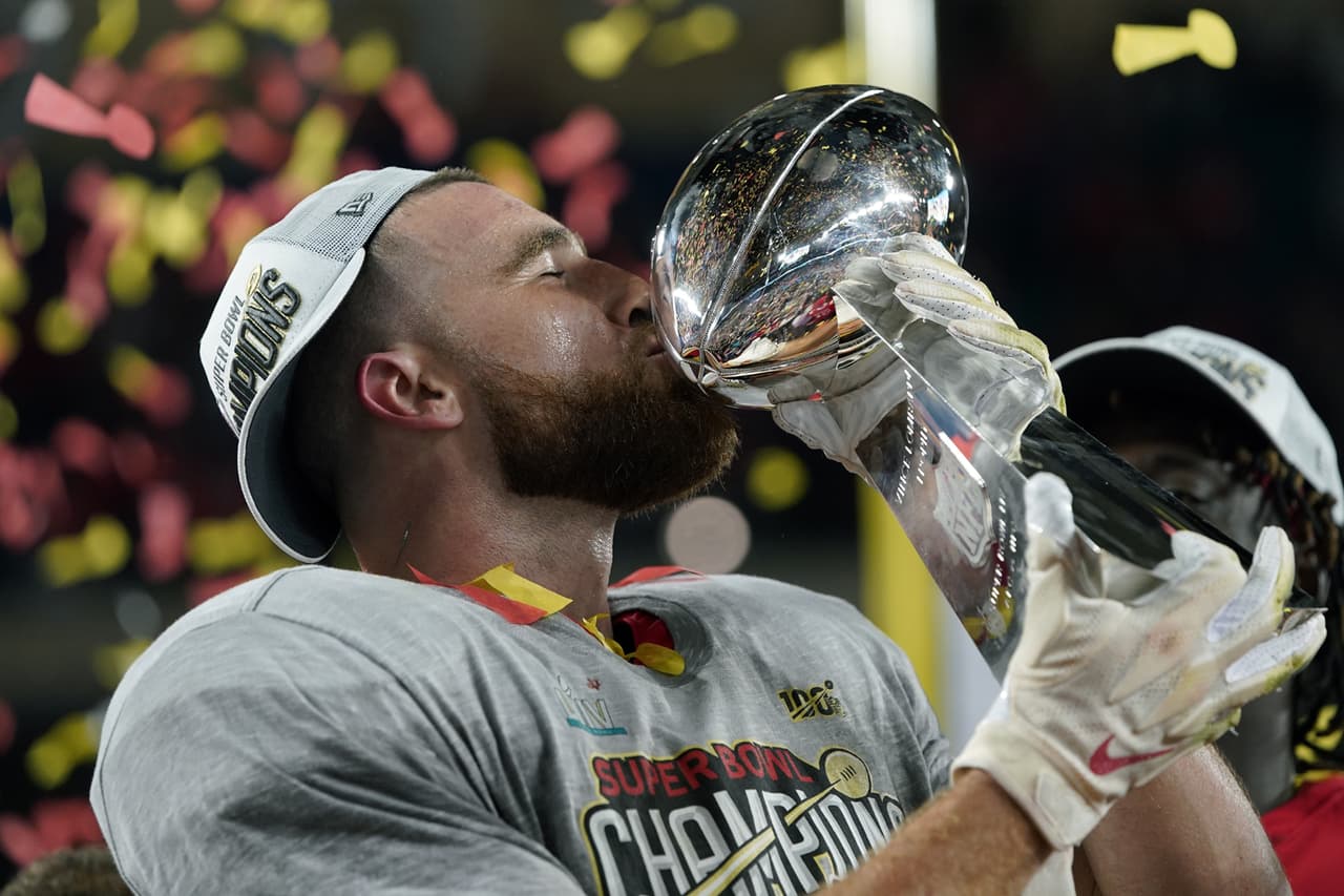 Travis Kelce bebe del trofeo Vince Lombardi