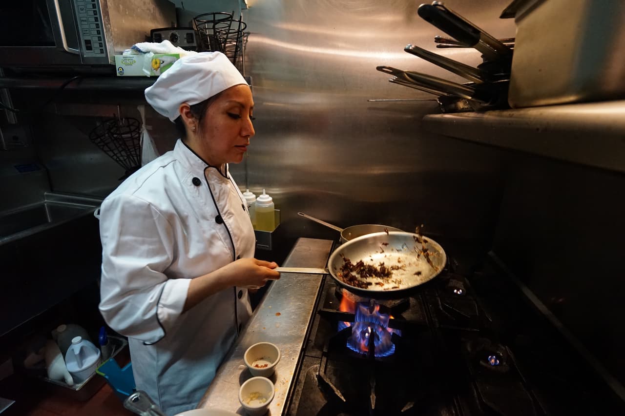 La cocinera guisa las recetas de su familia.