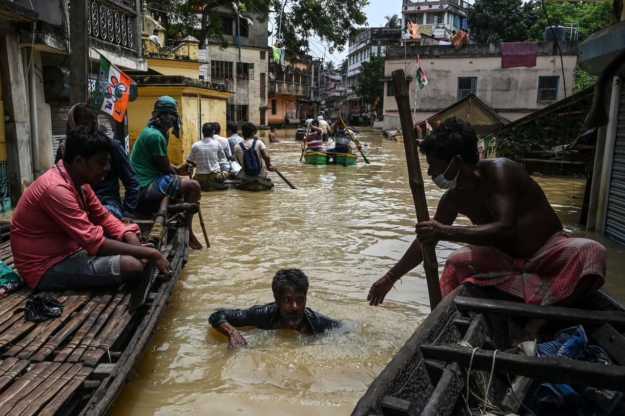 <b>Lluvias devastadoras en el sur de Asia</b>
<br>
<br>Un hombre con el agua hasta el cuello recibe ayuda en una calle inundada de Ghatal, India, luego de las fuertes lluvias monzónicas que afectaron la zona a principios de agosto. El nuevo informe de la ONU enfatiza que el cambio climático está siendo inducido por el hombre con la emisión de gases de efecto invernadero.