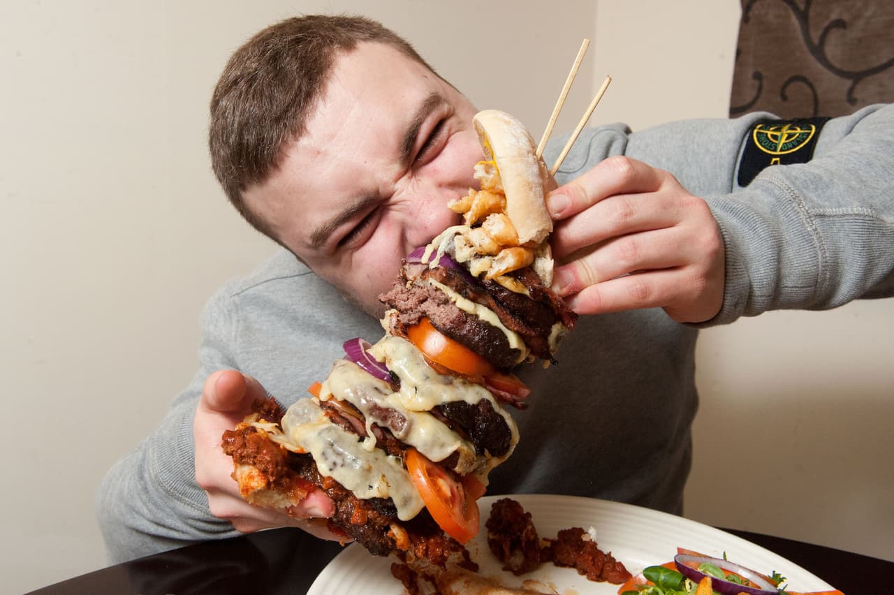 La hamburguesa de 12 pulgadas de alto comenzó a ser devorada por Theodorou.