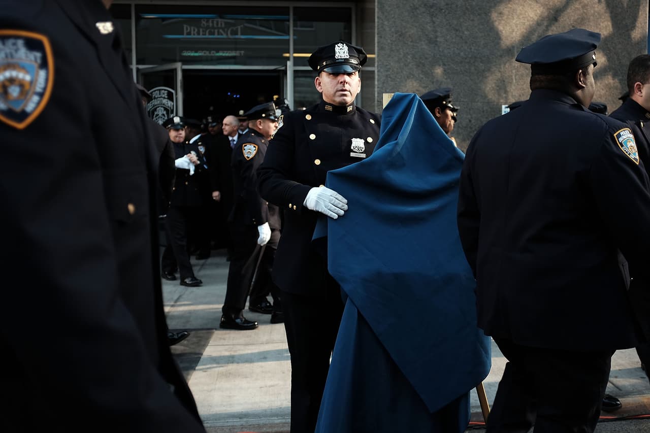 Funcionarios depositaron ofrendas florales en la acera cerca del lugar donde la patrulla de los policías se había estacionado.