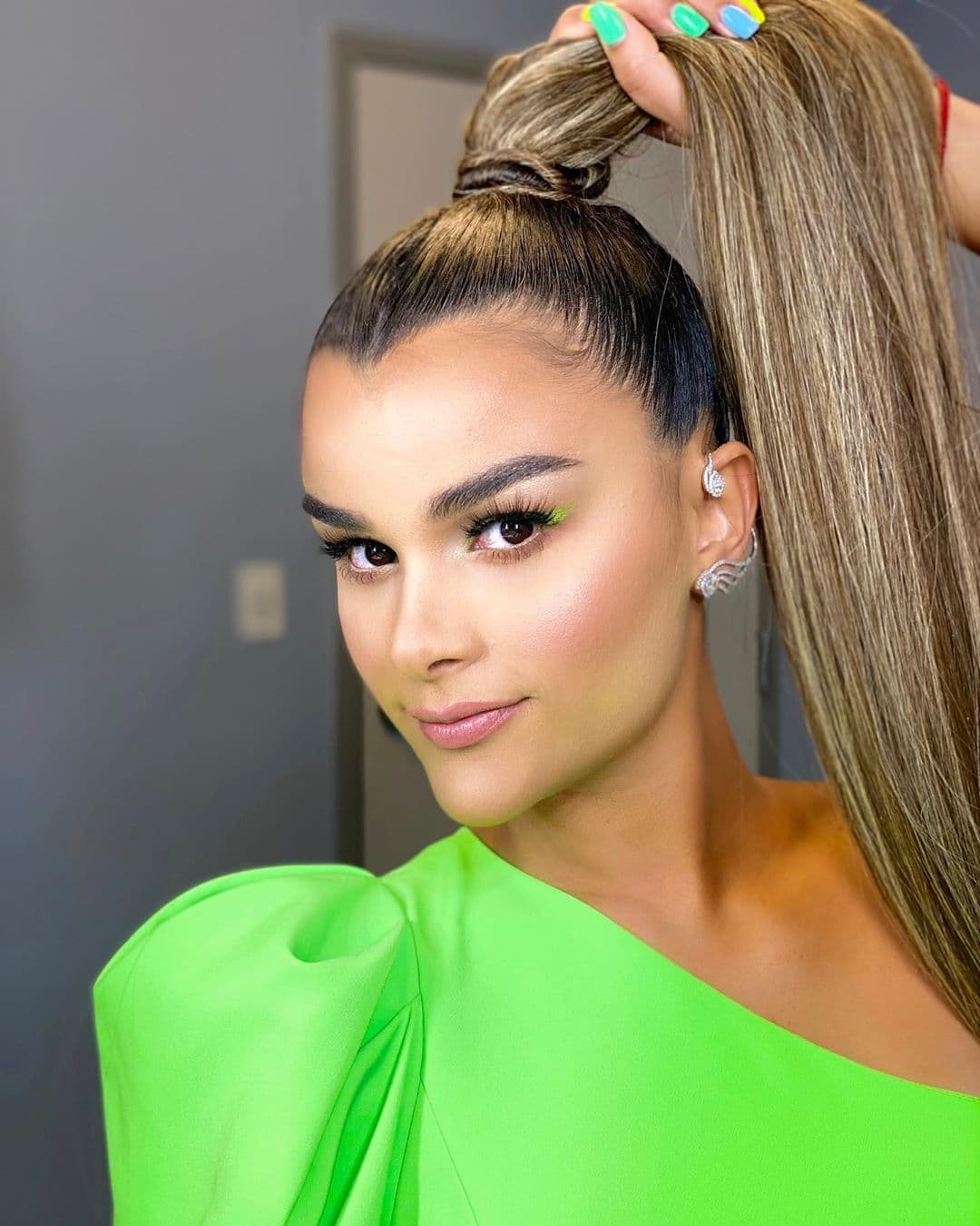 Las tonalidades neón siguen de moda y a Clarissa Molina la vimos usando esta tendencia en Nuestra Belleza Latina El Reencuentro. ¿Qué tal su coleta extra larga y el maquillaje con destellos de color?