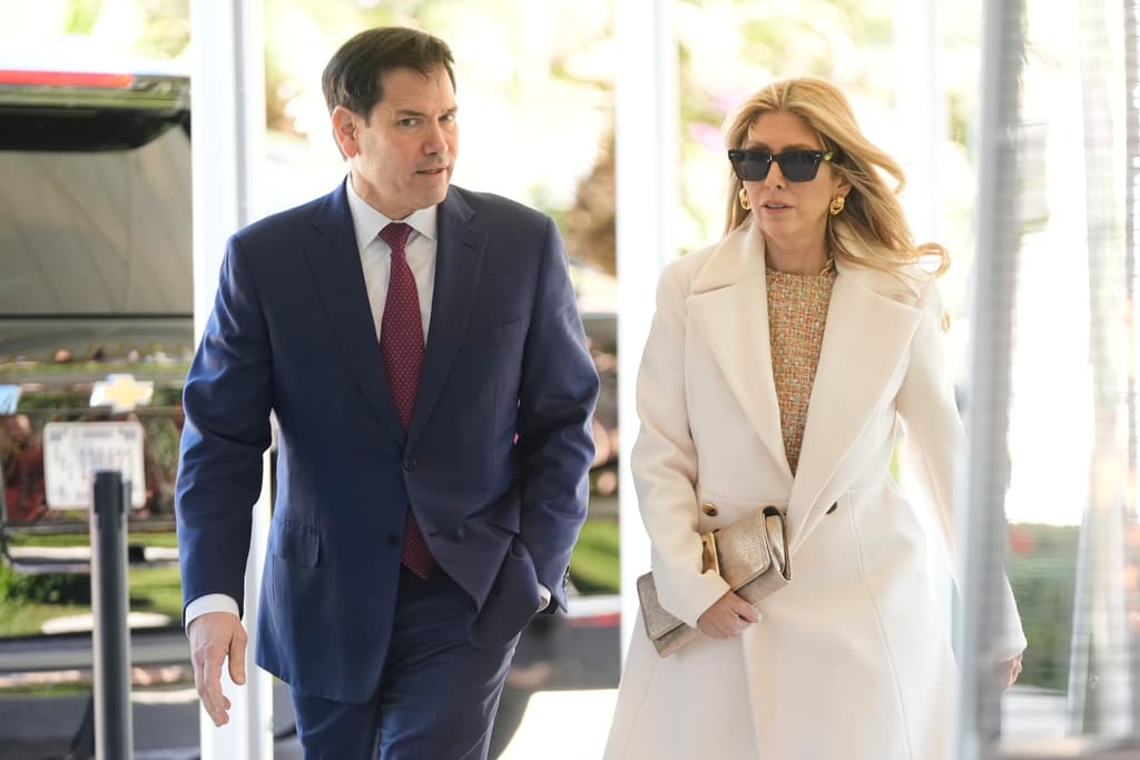 El secretario de Estado, Marco Rubio, platicaba con su esposa Jeanette Dousdebes mientras se dirigían a la celebración del matrimonio entre sus colegas.
