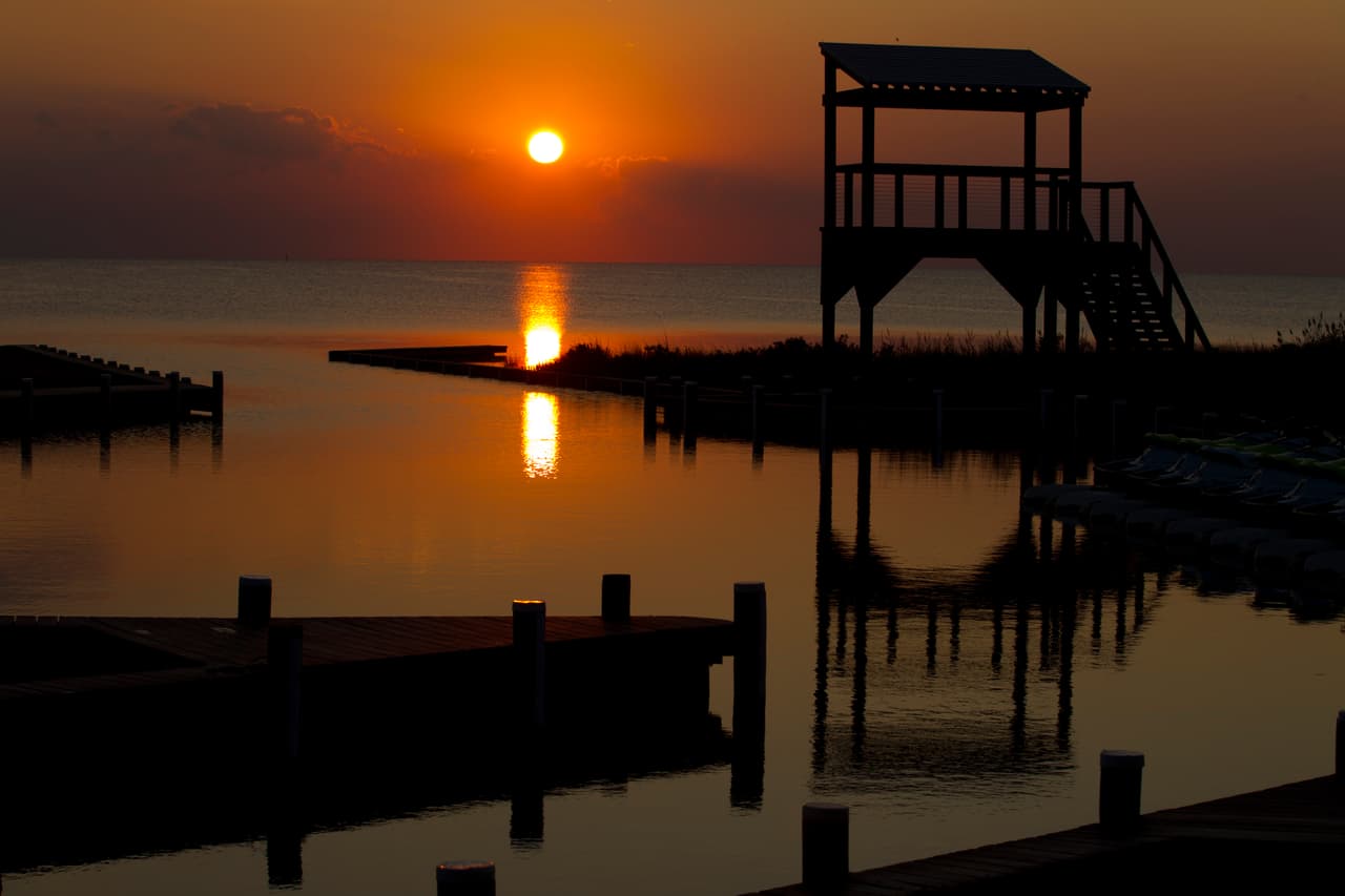 <b>The Outer Banks</b>. Un tramo de 130 millas de islas barrera frente a la costa de Carolina del Norte, The Outer Banks es un lugar diferente. Bellamente natural, formado por siglos de viento, agua y arena del Océano Atlántico, y hogar de una rica historia, es un lugar que inspira un verdadero sentido de aventura.