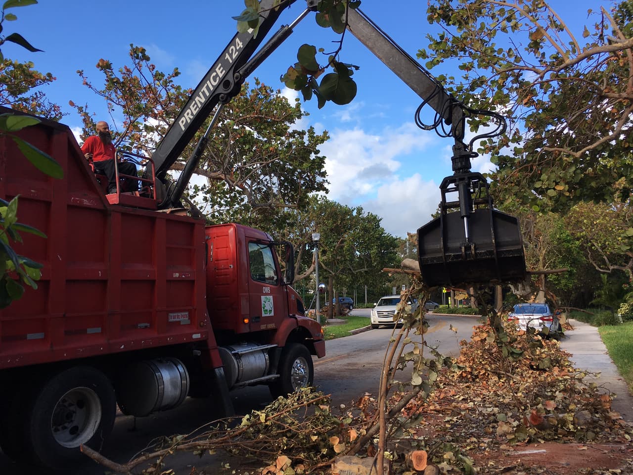 Johnny López recoge desechos de Irma en un camión. que los residentes dejaron en la acera. Manejar el gancho de su camión requiere conocimiento de la herramienta. Foto: David Adams