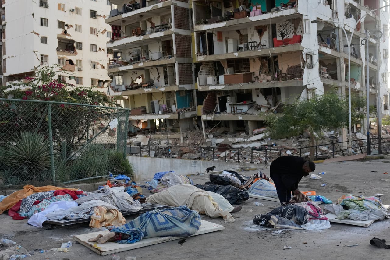 Ezequiel Frontado observa los cuerpos cubiertos mientras busca a sus familiares desaparecidos tres días después de que los terremotos azotaran Catia La Mar, Venezuela, el sábado 27 de junio de 2026.