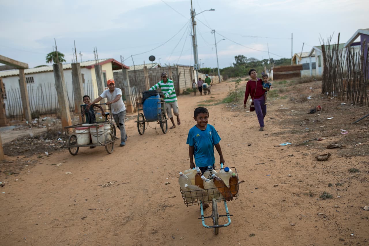 Los residentes de Villa Esperanza, a las afueras de Maracaibo, se ven obligados a llevar botellas de agua en carretillas a sus casas. Algunos de los casos de miseria más graves se repiten a diario en las calles de esta ciudad, la segunda de Venezuela, que en su día fue el corazón de la floreciente industria petrolera.
